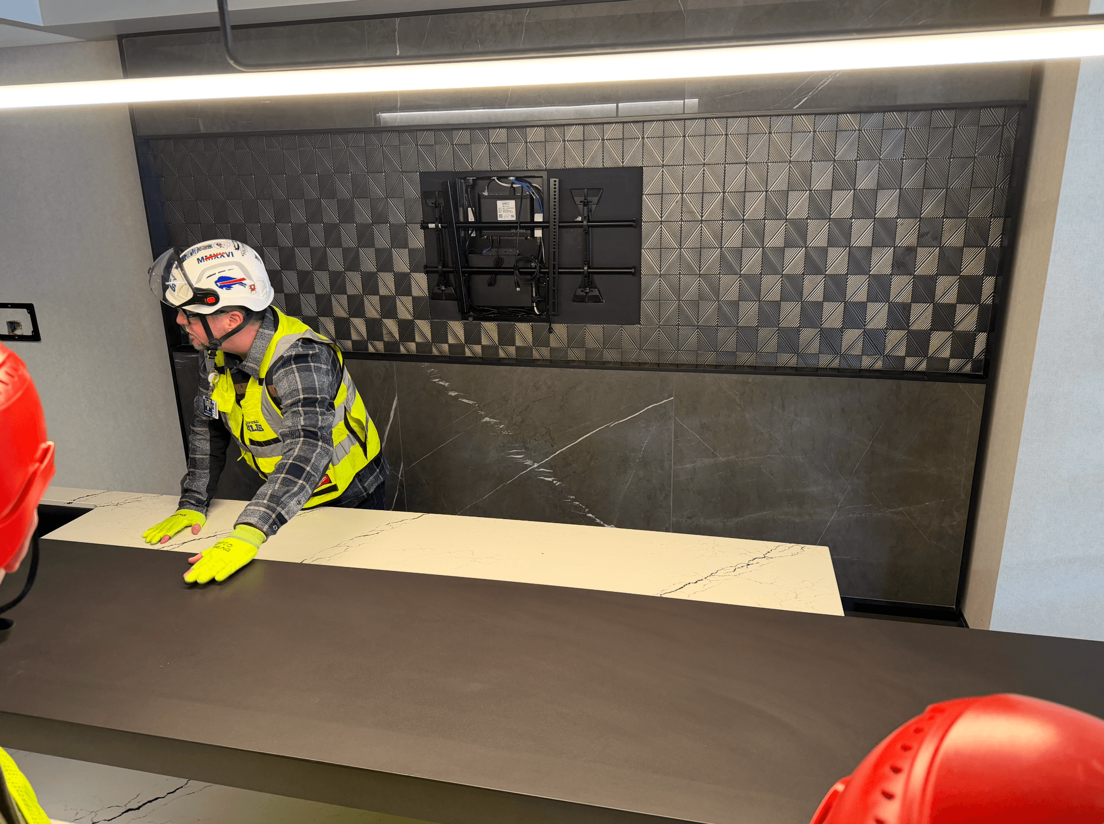 A worker in a Bills hard hat leans on a counter in a suite on the 200 level of the new stadium.